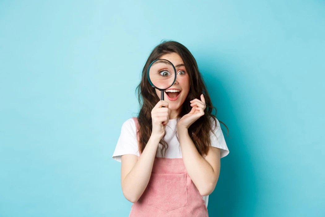 happy-young-woman-looking-through-magnifying-glass-with-excited-face-found-search-something-standing-blue-background-optiweb.jpg