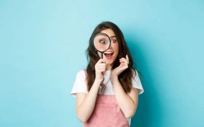happy-young-woman-looking-through-magnifying-glass-with-excited-face-found-search-something-standing-blue-background-optiweb.jpg