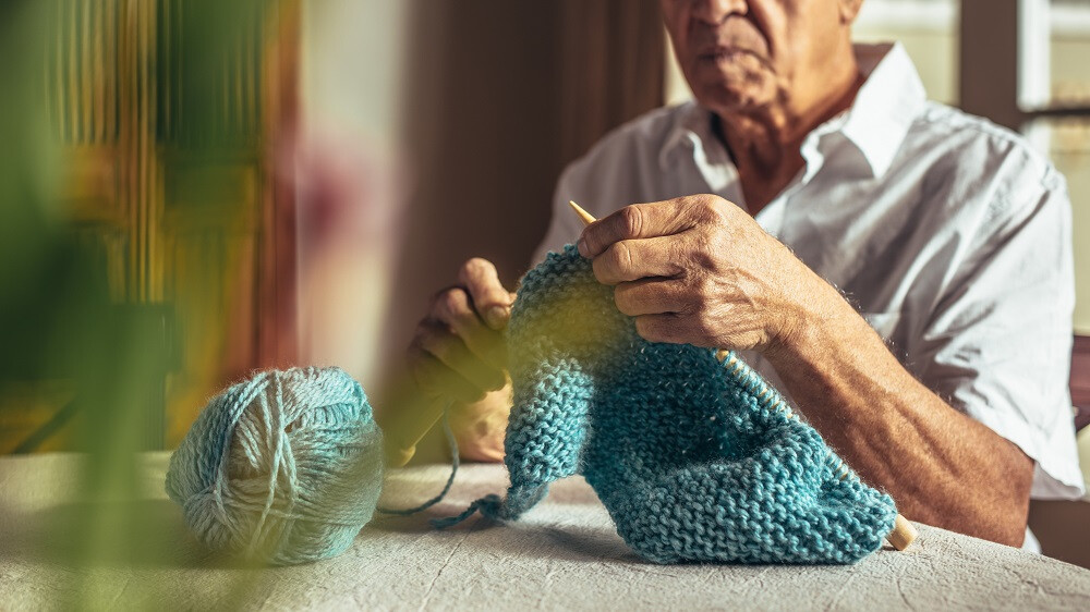 Homme senior qui tricote