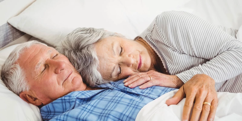 Couple de seniors qui dort dans son lit