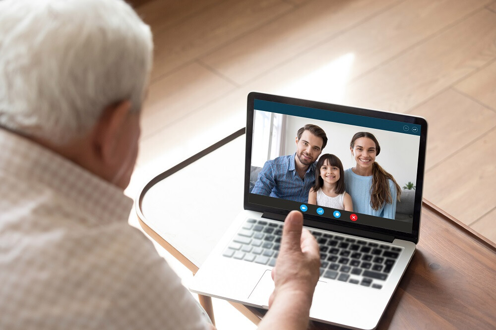 Homme senior communique avec sa famille par internet