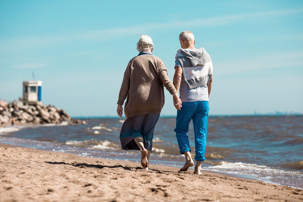 Couple personnes âgées marchent sur la plage